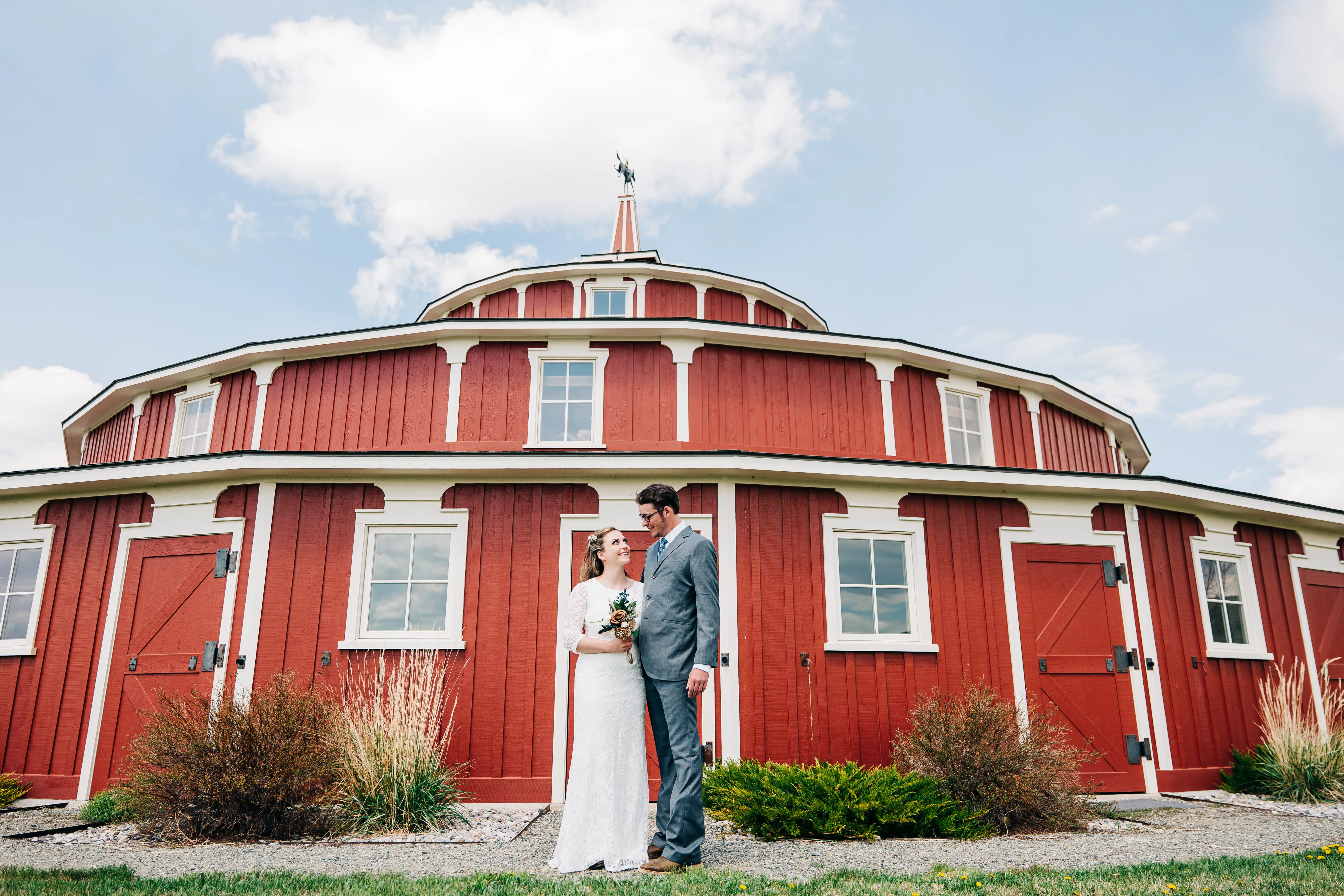 Couple Standing In Front Of The Round Barn At Twin Bridges Wedding Venue In Montana